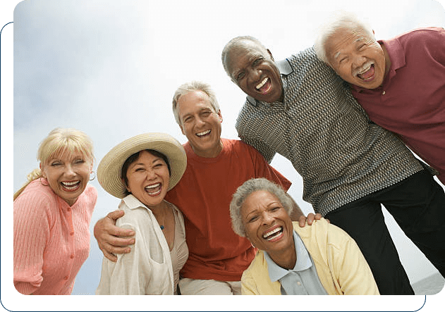 A joyful group of senior friends huddled together, laughing and enjoying each other's company.